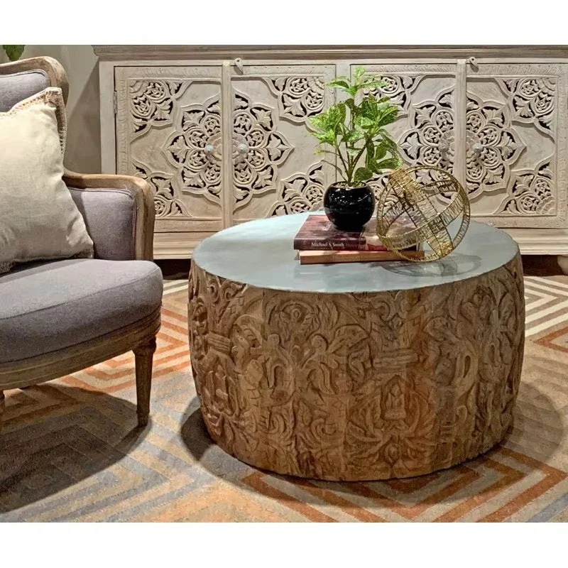 Round carved wooden coffee tables with intricate floral patterns and natural faux-vintage finishes are suitable for stylish