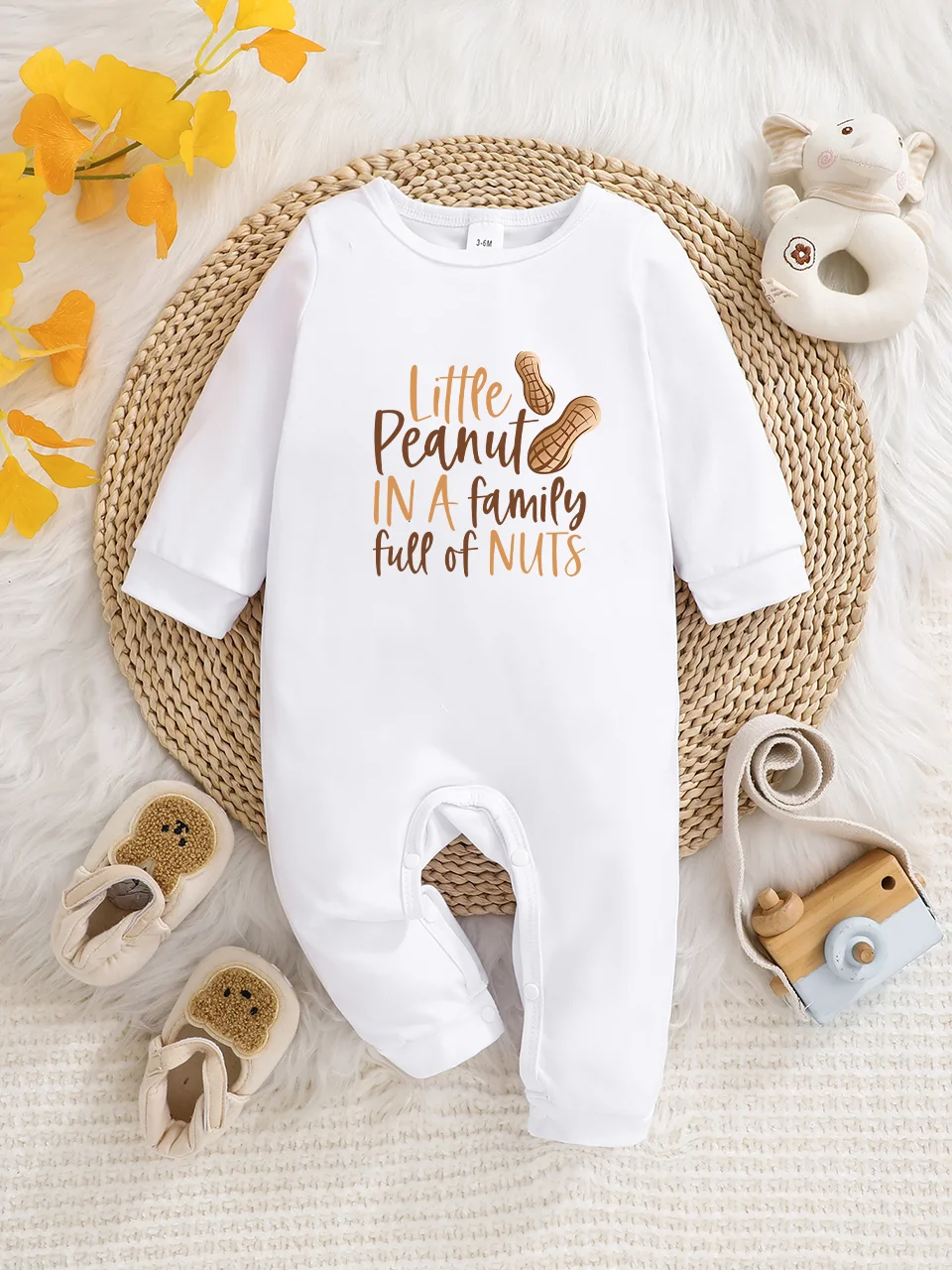 Ein langärmeliger Baby-Strampler mit interessanten Buchstaben-Prints. Es verfügt über ein Knopfverschluss-Design für einfaches An- und Ausziehen, und