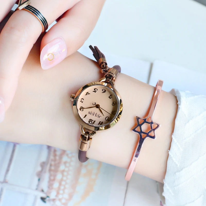 ساعة نسائية على الطراز الكوري بحزام رفيع وحزام جلدي رقيق وشرابة على الطراز القديم. ساعة وإكسسوار للنساء.