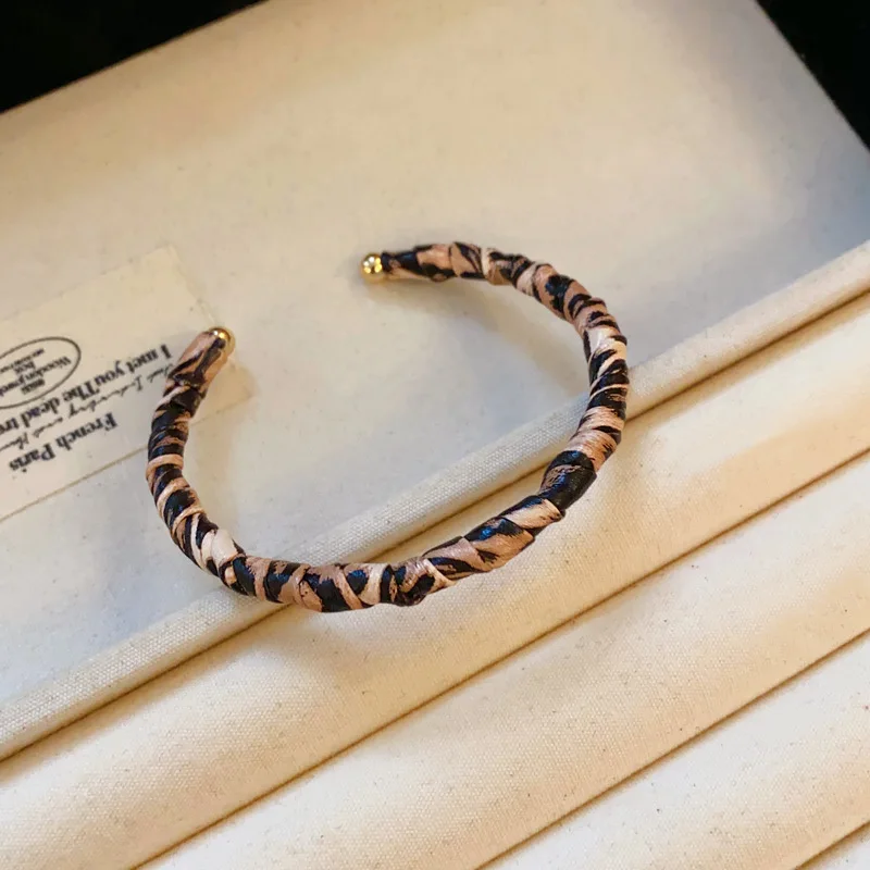 Bransoletka w panterkę, skręcana, plisowana, otwarta, retro, skórzana, w stylu etnicznym, personalizowana, niszowa, z charakterystycznym designem, ozdoba na rękę.