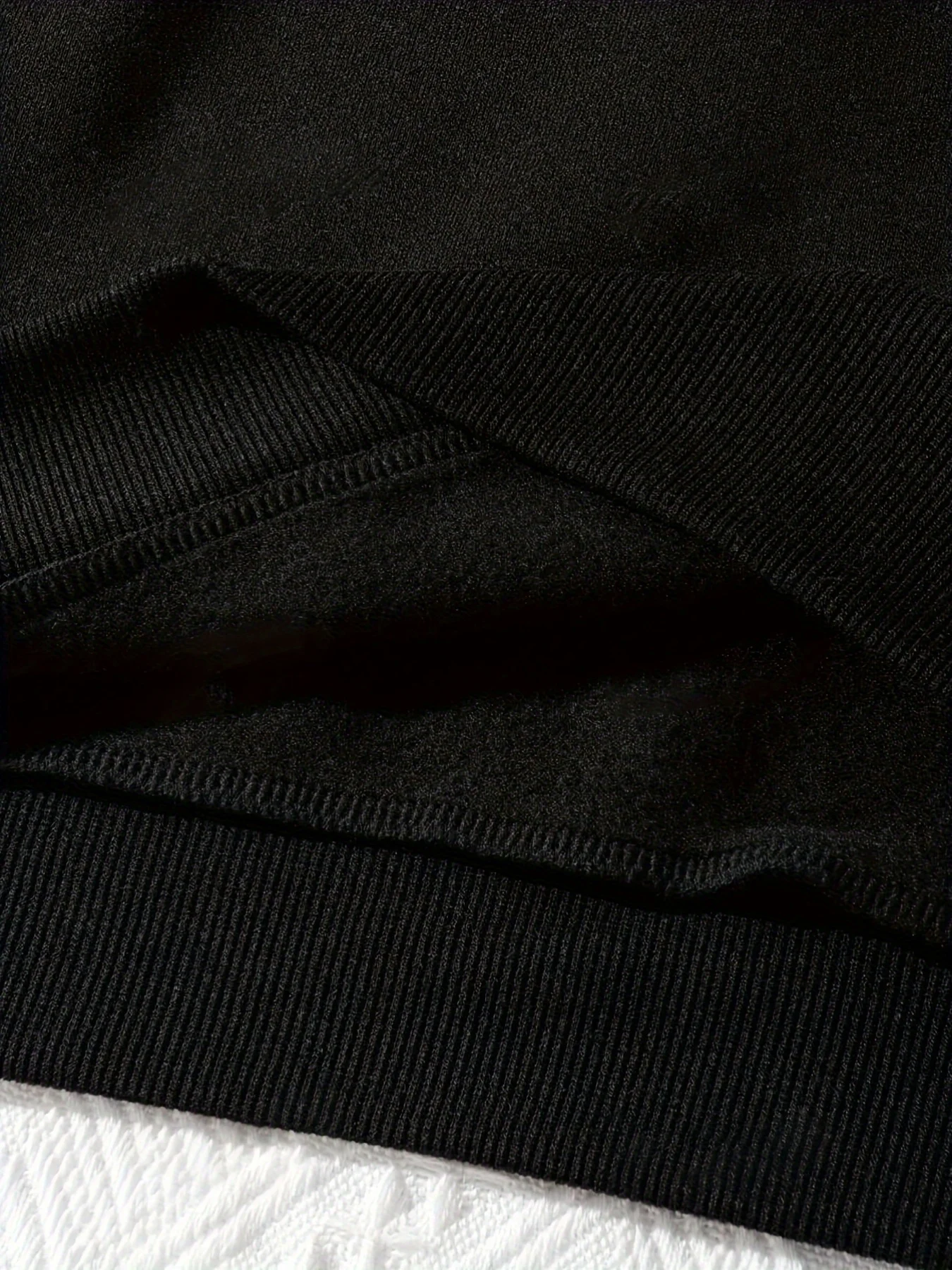 Un sweat à capuche saisonnier mondial avec une base noire imprimée avec les mots "To Teach is to Love" en fibre de polyester lavable en machine