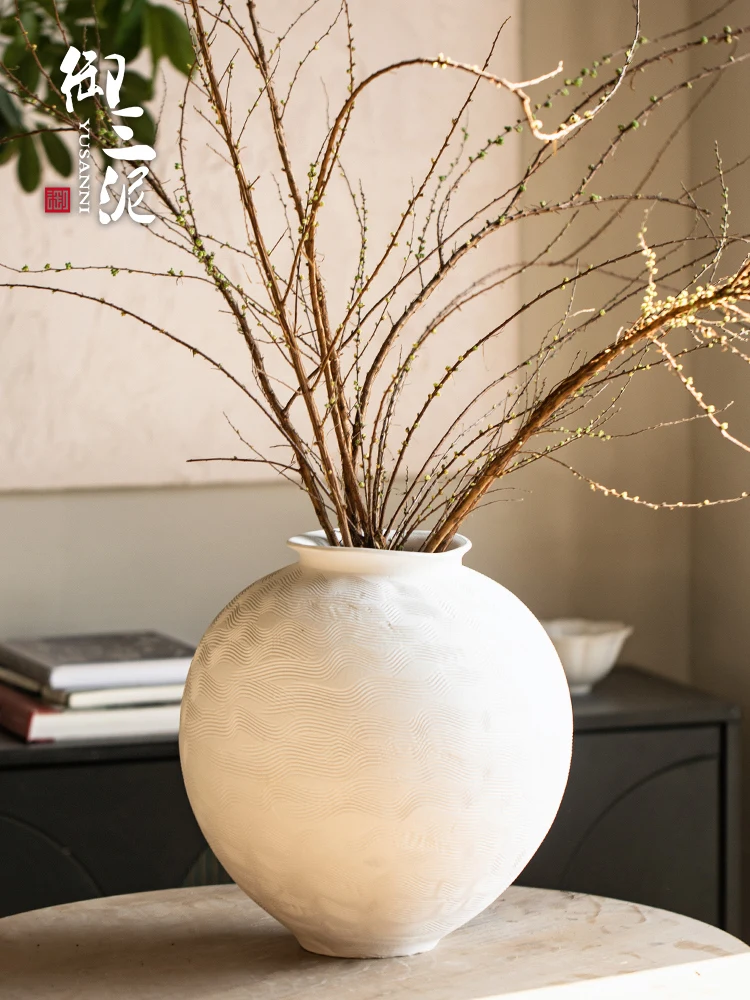 Hand-drawn coarse pottery vase, white moon jar with dried flower ornament, water-raised flowers in the living room