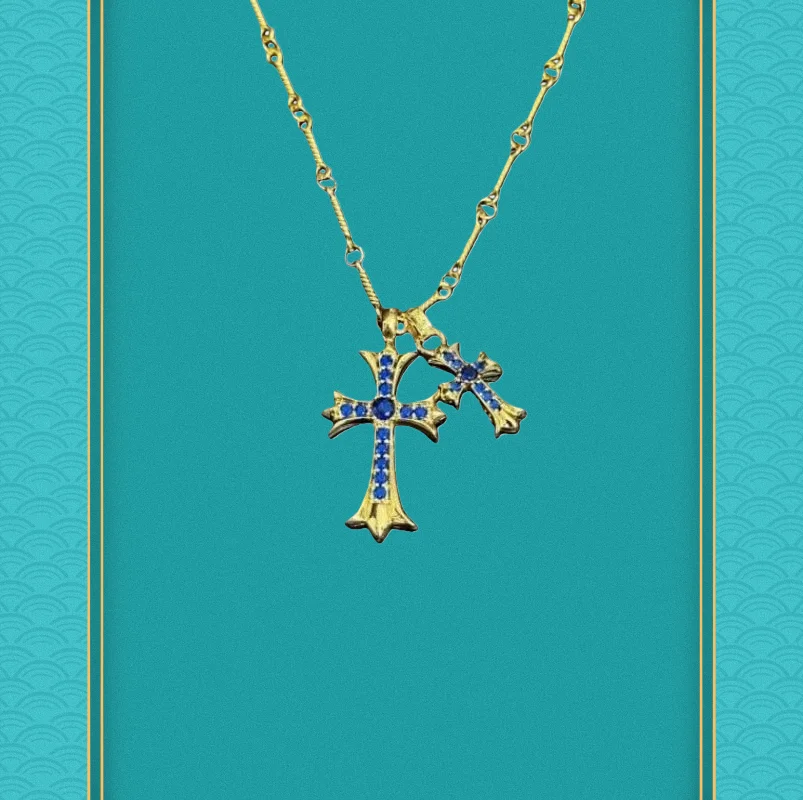 

Стильное золотое колье с двойным крестом и сапфировыми стразами