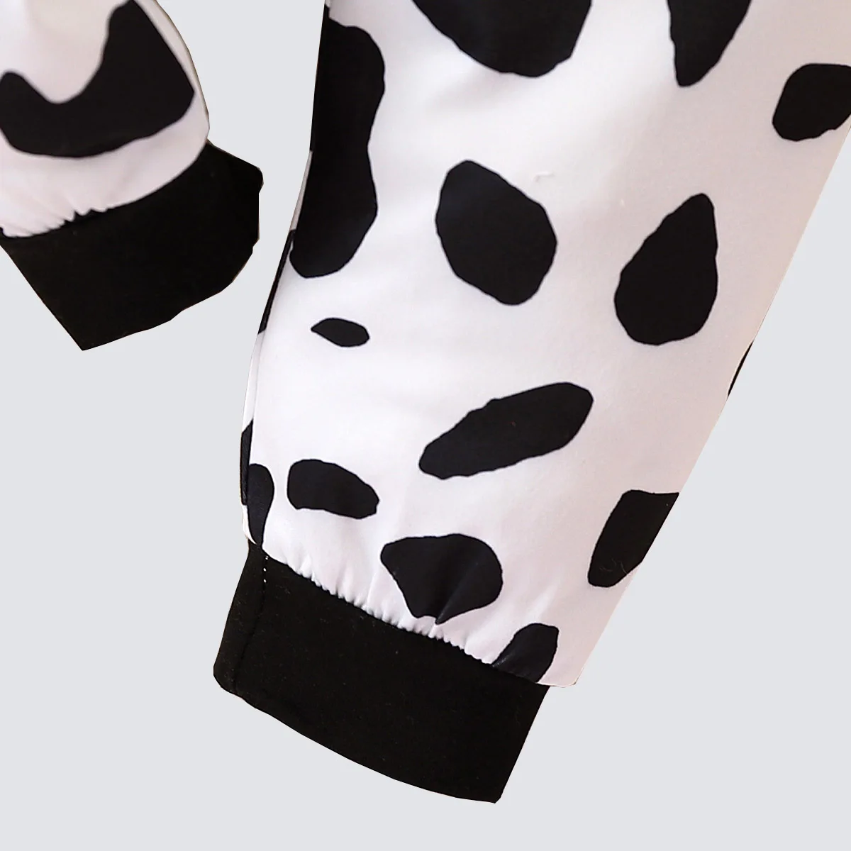 Two piece cute and fashionable black and white spotted cow print long sleeved round neck top and pants set for baby boys