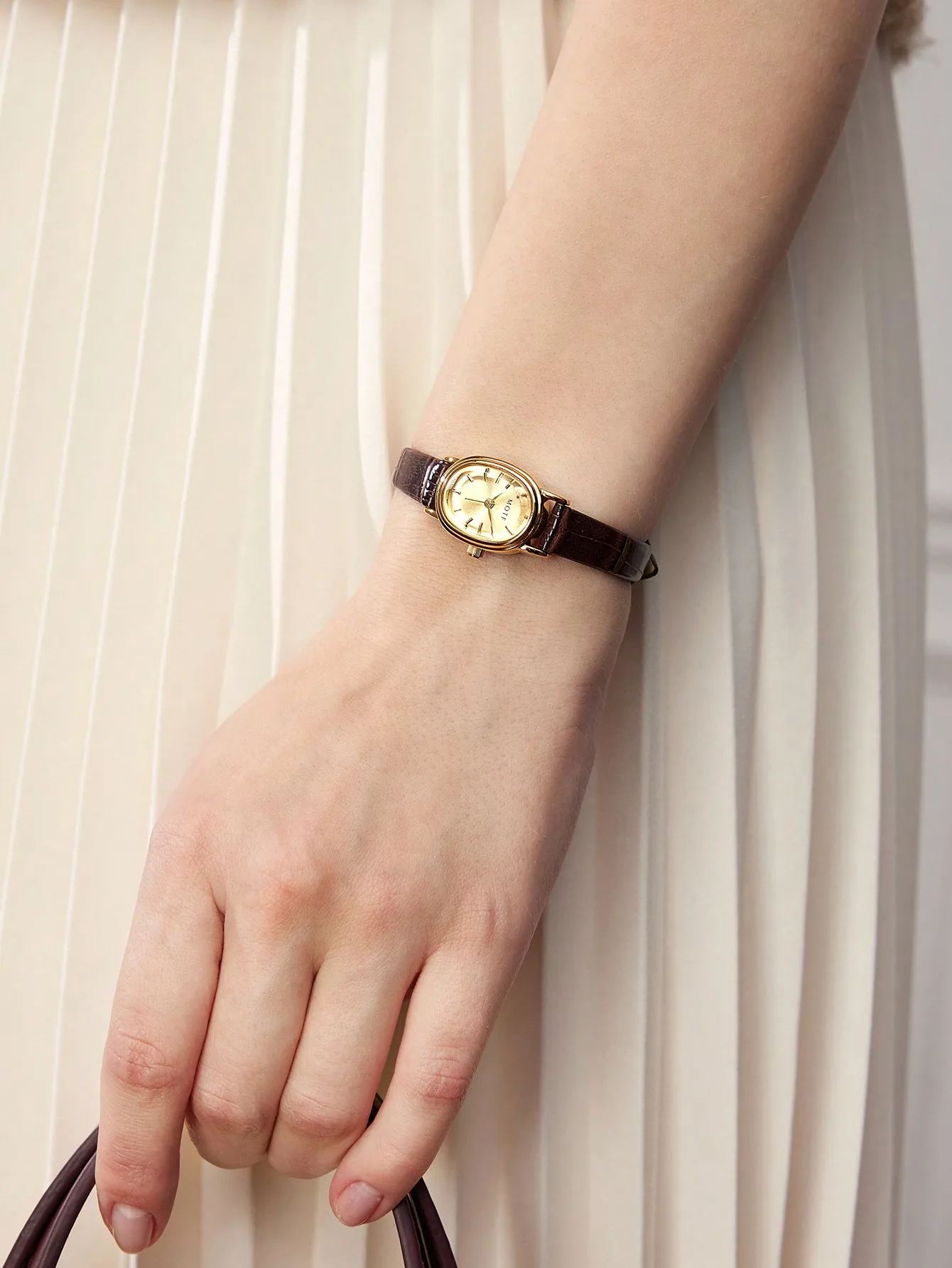 

Элегантные женские часы с овальным циферблатом, золотистым корпусом и коричневым кожаным ремешком.