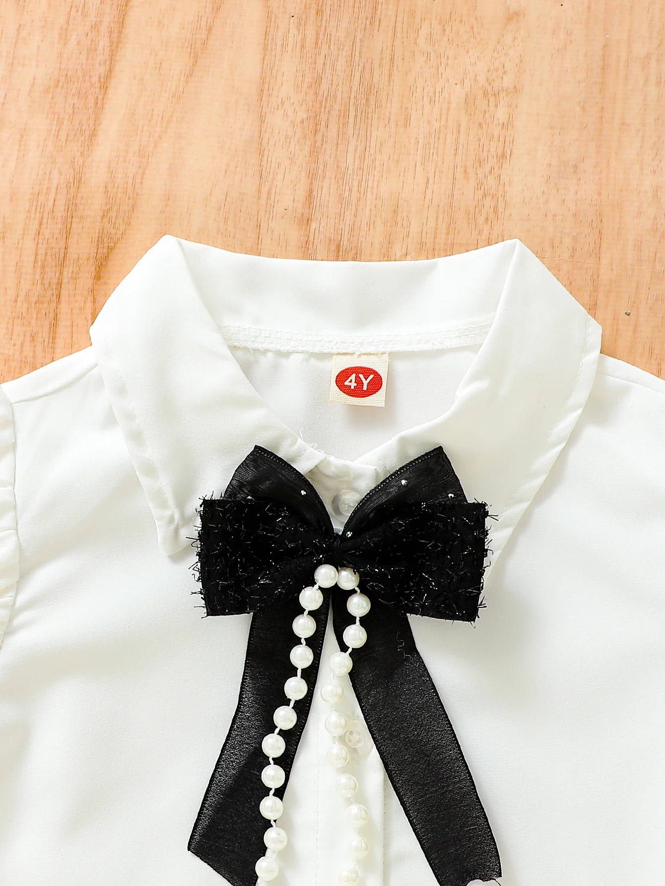 The new summer girls\' bubble-sleeved blouses are paired with bow accessories and a black half-length cake skirt