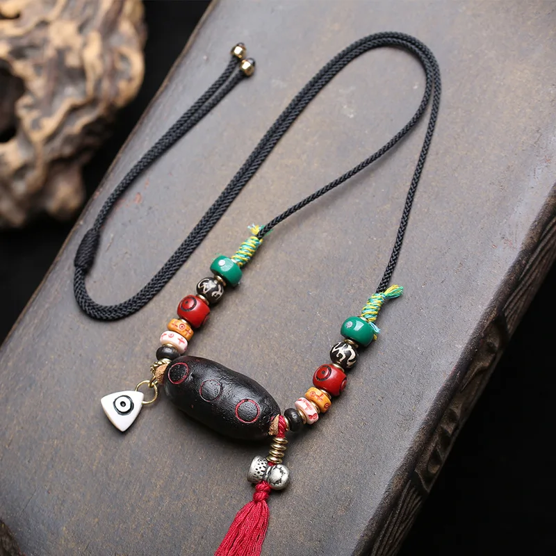 

Hand-woven rope necklace with Tibetan-style Nyingma School “Rahu La” pendant; collarbone chain with recycled beads