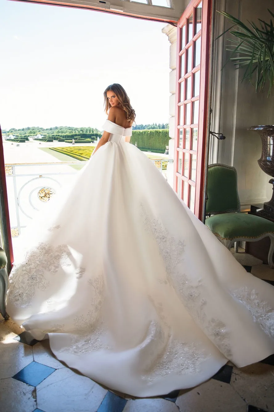 Suknia ślubna z dużą spódnicą, odkrytymi ramionami i plecach, z satynowymi aplikacjami z cekinami, model 2026, szyta na miarę.