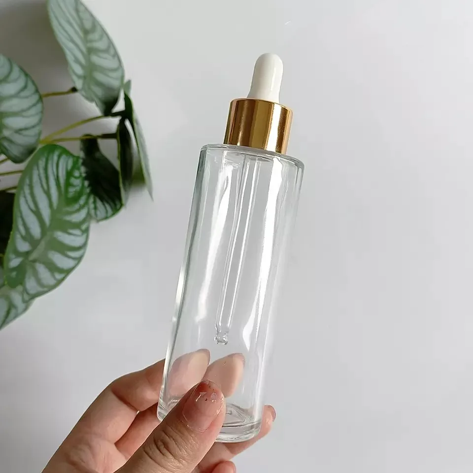 Wholesale 20-100ml Transparent Flat Shoulder Glass Essential Oil Serum Dropper Bottle With Gold Lid Skin Care Emulsion Container