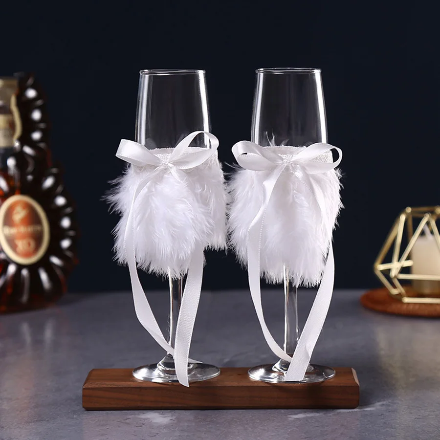 

A pair of wedding champagne glasses, feathered and decorated with bows, suitable for the wedding season Valentine's holiday