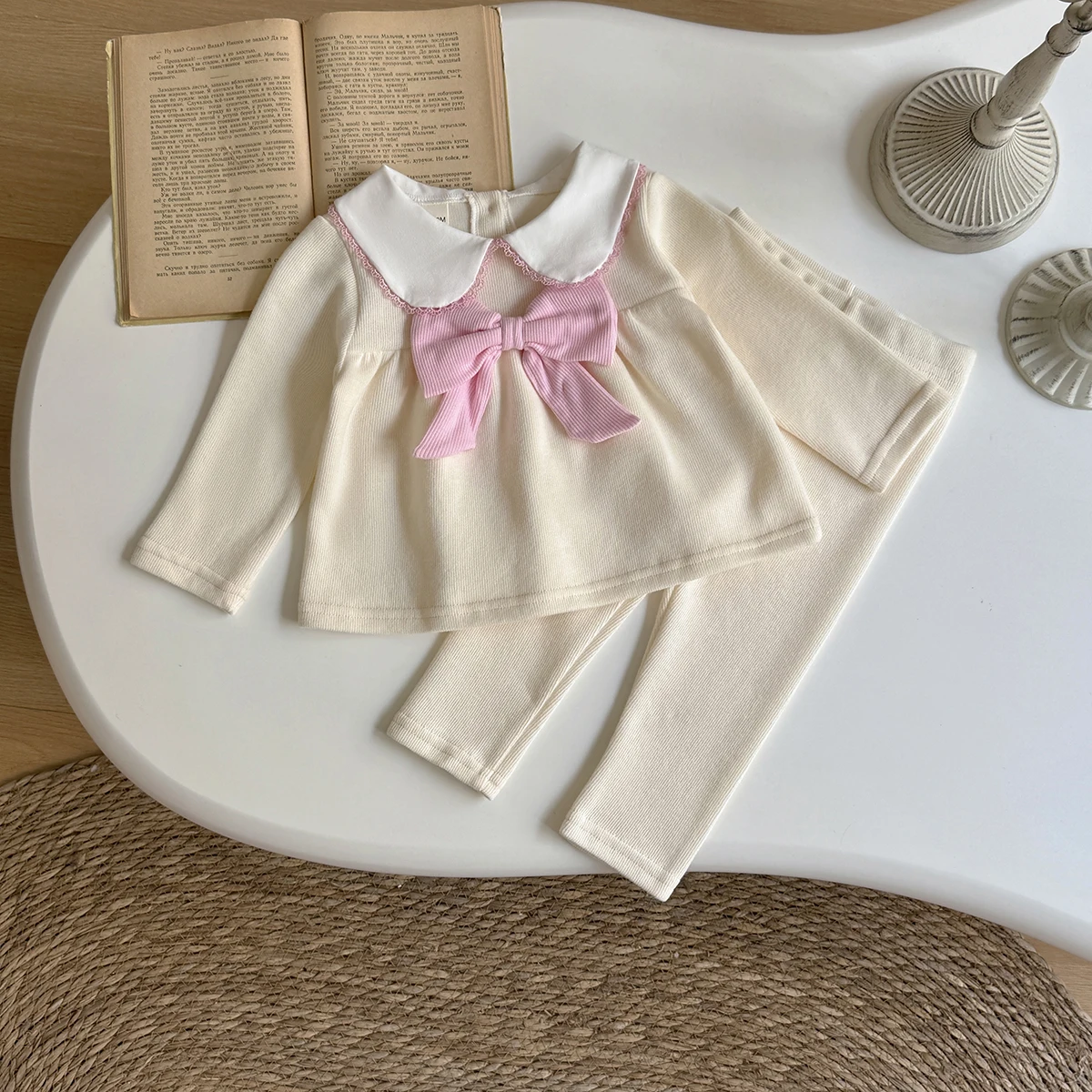 

Комплект для девочки: однотонный пуловер с воротником-бантом и длинными рукавами, облегающие брюки однотонного цвета. Весенне-осенний комплект из двух предметов для малышек.