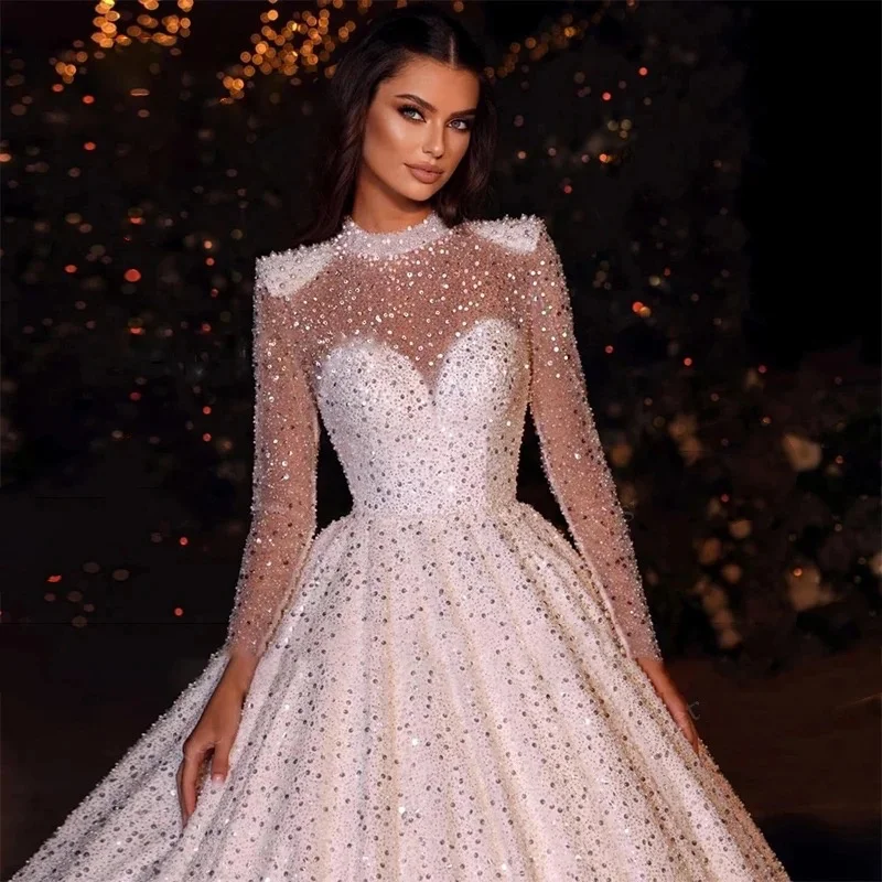 فستان زفاف أنيق لامع مخصص مطرز بالخرز والدانتيل والترتر فستان عروس برقبة عالية وأكمام طويلة فيستدو دي نوفيا