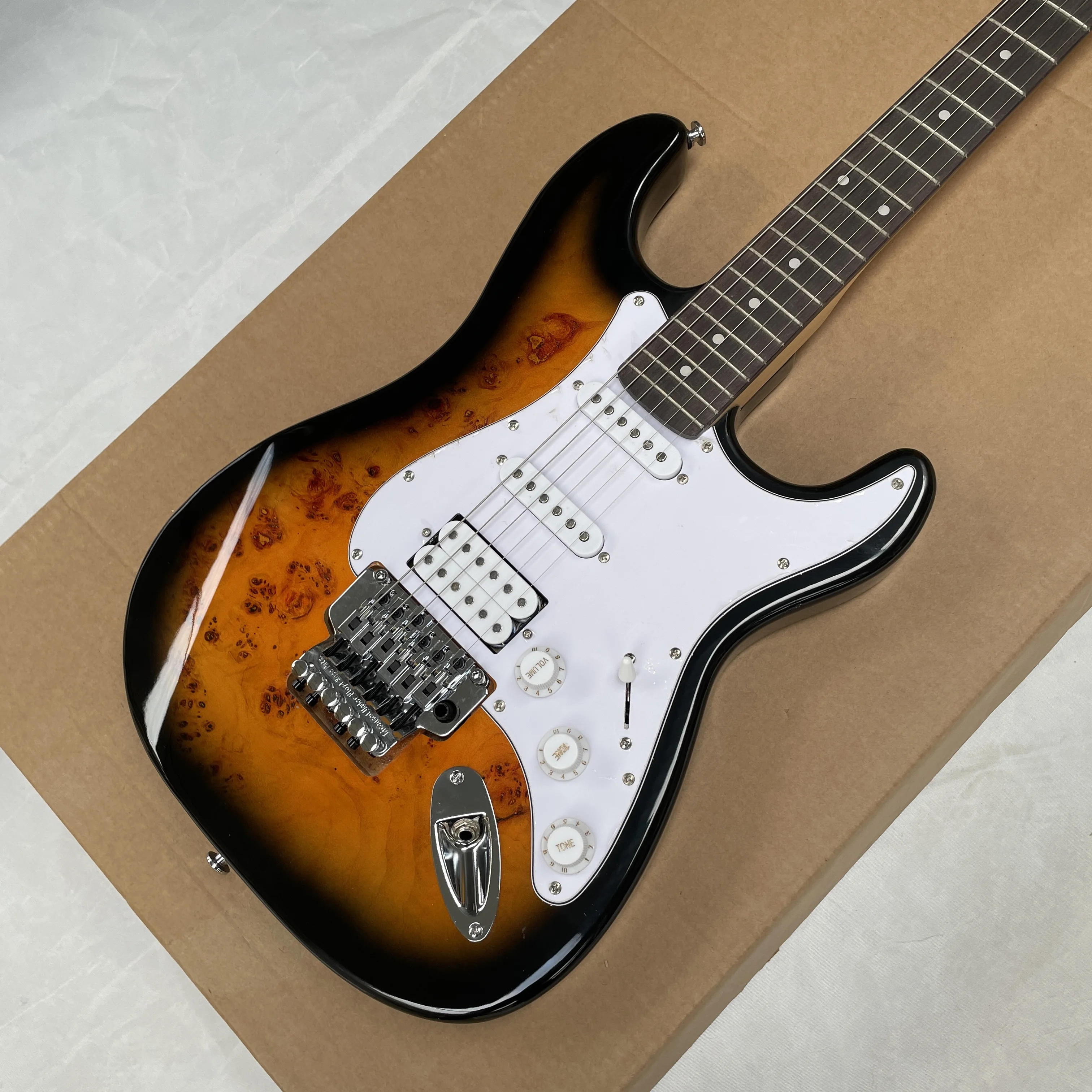 

6-струнная электрогитара с белой накладкой на гриф и звукоснимателями SSH, с системой двойного блокирования тремоло.