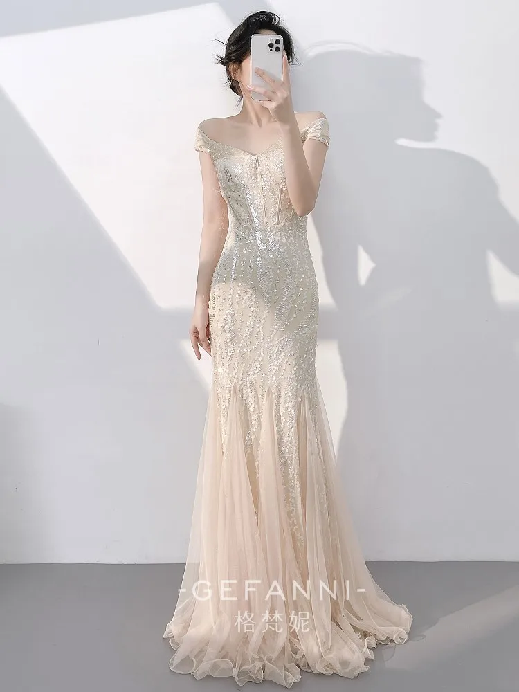 

A champagne-colored stylish and elegant one-shoulder fishtail sequined long dress for the host