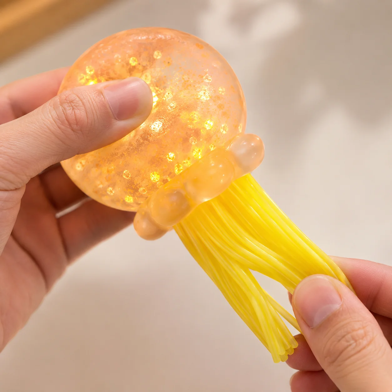 Brinquedo de medusa transparente com lantejoulas de 4 cores e tentáculos de silicone macios e elásticos. Brinquedo fofo anti-stress com luzes LED que brilham quando apertado, perfeito como um presente fofo para aniversários, festas, Natal e Halloween.