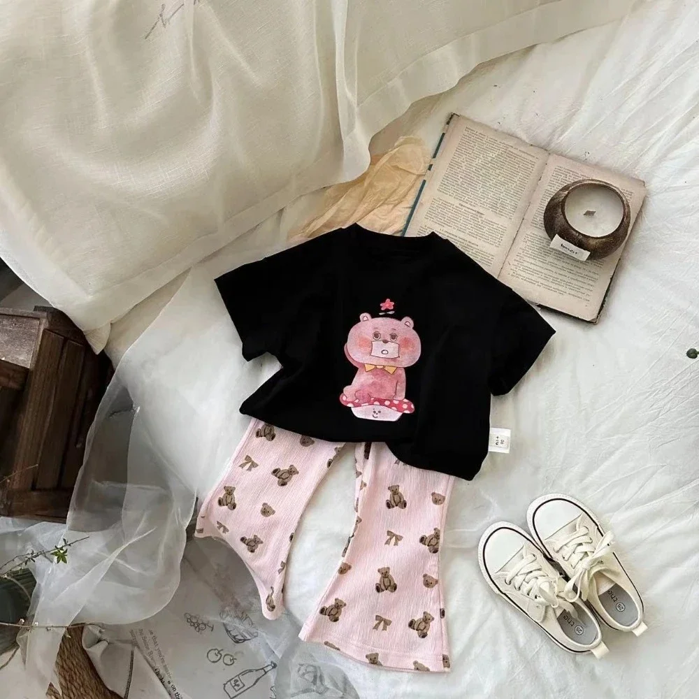 

Летняя корейская версия, милая и милая повседневная одежда для девочек, черная футболка с короткими рукавами и расклешенными брюками с принтом медведя + комплект из двух предметов