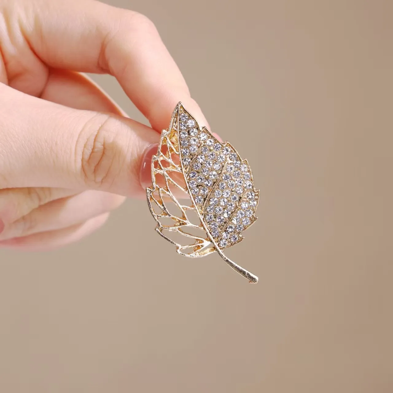 بروش فاخر مرصع بالألماس المتلألئ على شكل أوراق ذهبية يفتح نمط أنيق رائع يعرض الملمس الراقية ورائع