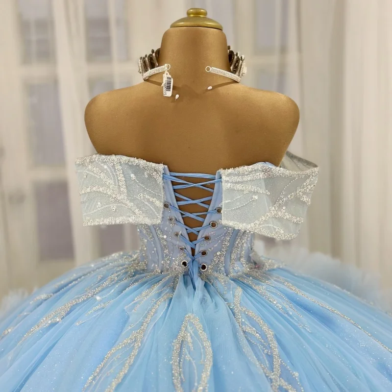 ชุดเดรส Quinceanera สีฟ้าสั่งทำพิเศษ แบบเปิดไหล่ ประดับคริสตัลวิบวับ แต่งลูกไม้ดอกไม้ ชายกระโปรงยาว  ชุดราตรีงาน Quinceanera อายุ 15 ปี
