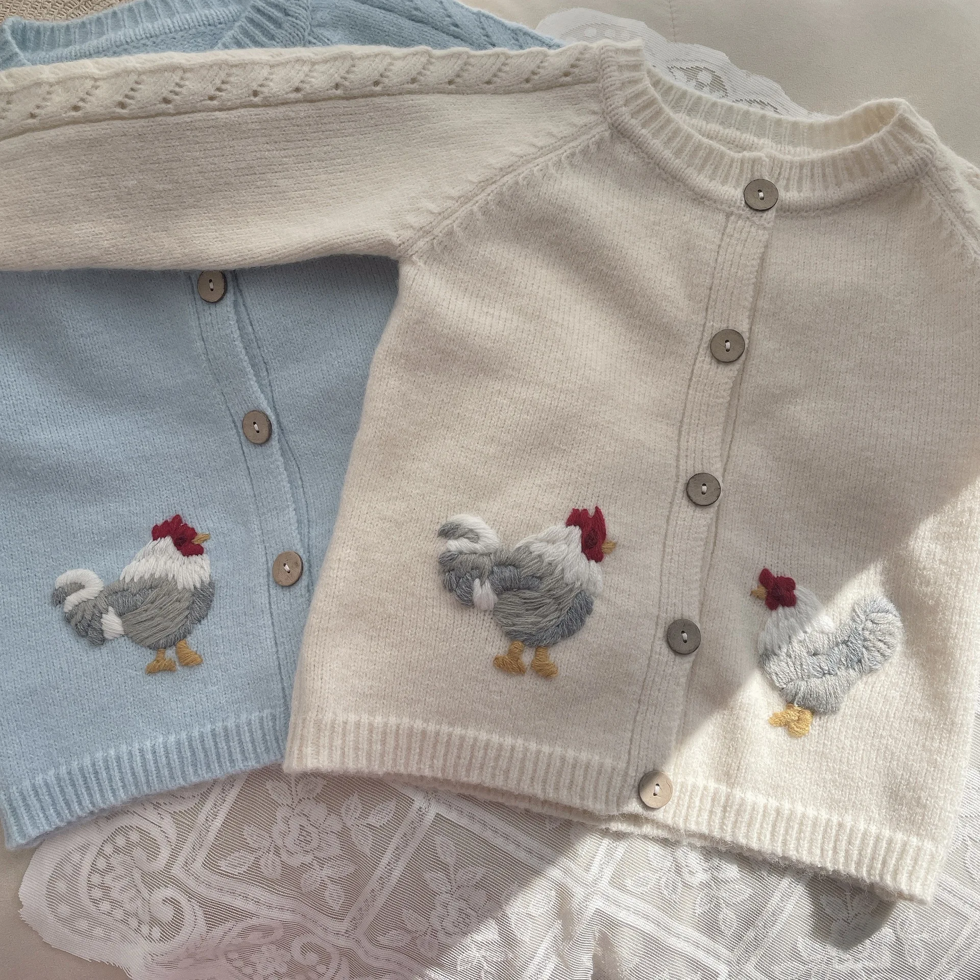 The new spring knitted cardigan wool sweater with hand-embroidered details for baby girls features a minimalist Nordic ins-style