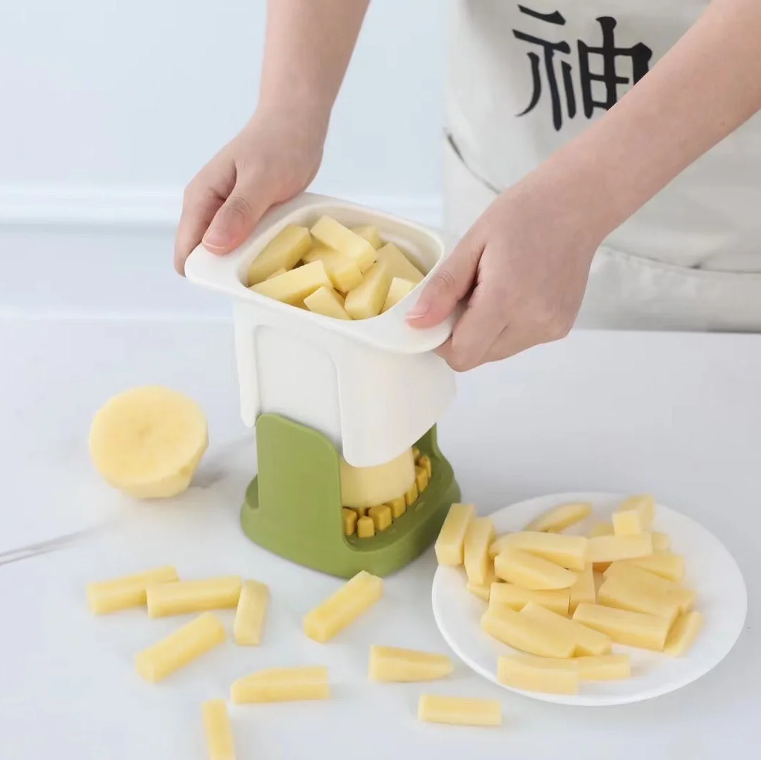 New household hand-pressed multi-function vegetable cutter, cutting potatoes and radishes in the kitchen