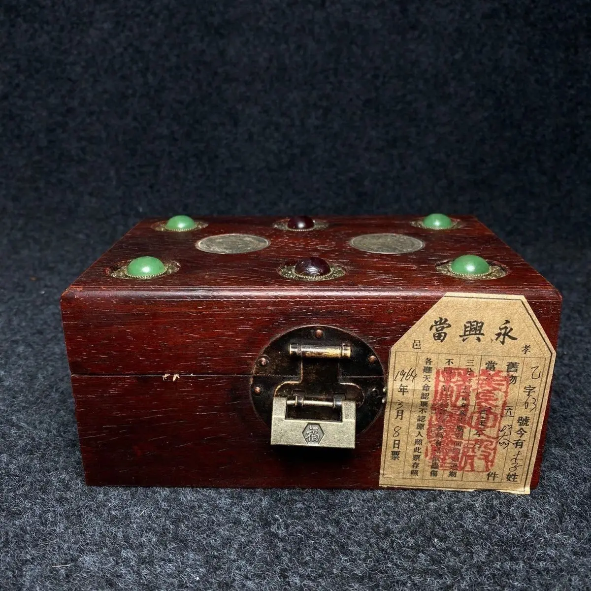 A piece of old jade sealed in a rosewood inlaid silver jewelry box