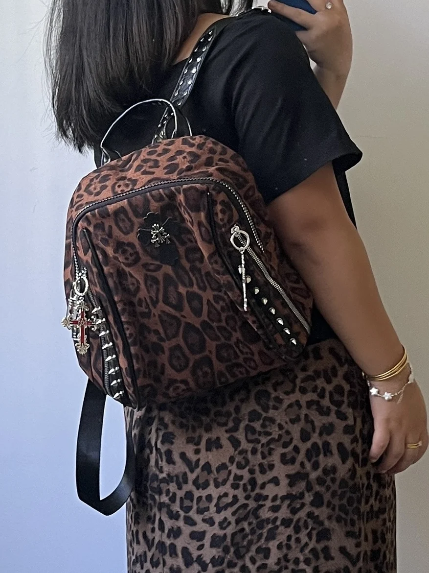 

2026 Новый оригинальный сексуальный леопардовый принт с металлическими заклепками и крестом, украшение, рюкзак в американском стиле ретро, персонализированная высококачественная женская сумка, модная