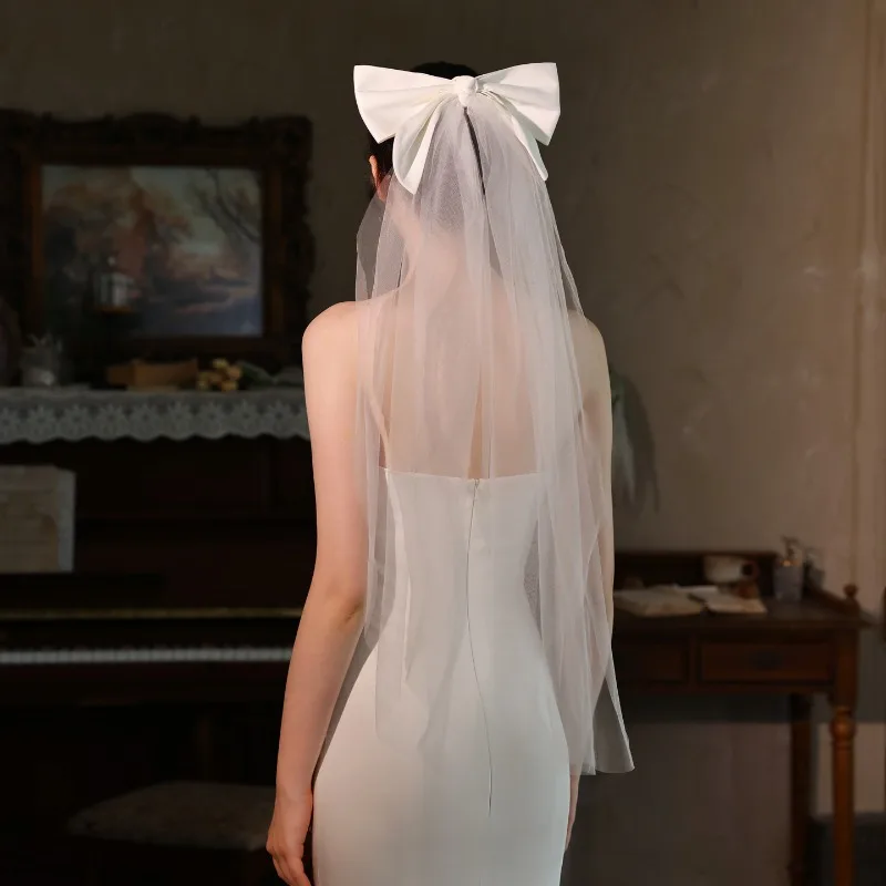 

Однослойный короткий головной убор с фатой невесты и белым бантом