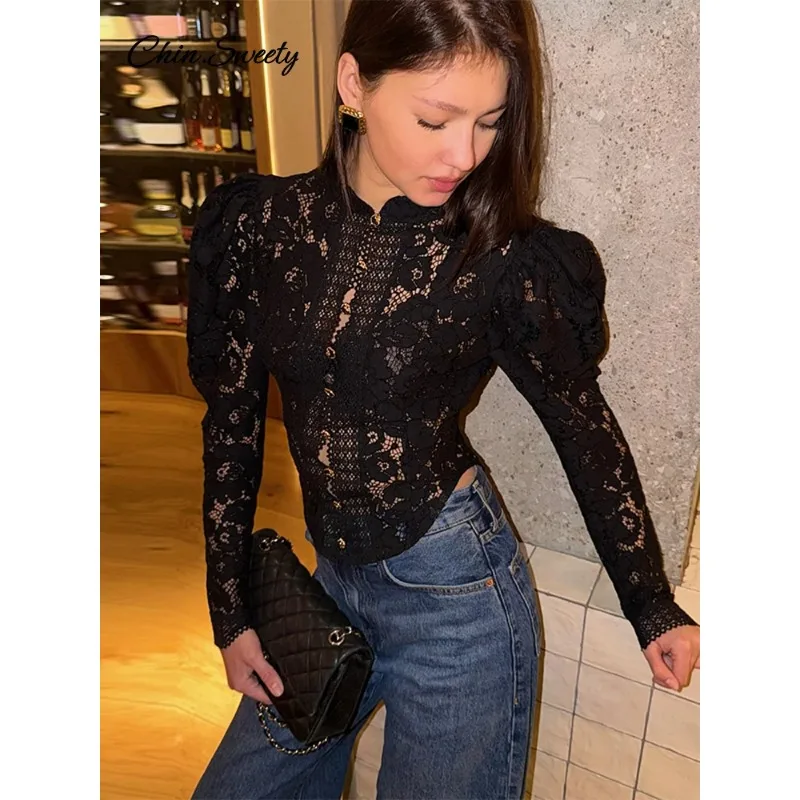 

Элегантный кружевной прозрачный женский топ с воротником-стойкой, длинными рукавами-фонариками и однобортной застежкой.