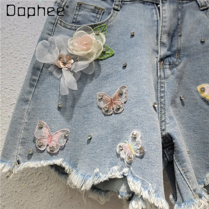 Pantaloncini di jeans personalizzati della stazione europea Donna 2025 Estate Nuova tendenza Perline strappate Ricamo floreale Pantaloni slim a gamba larga Alla moda