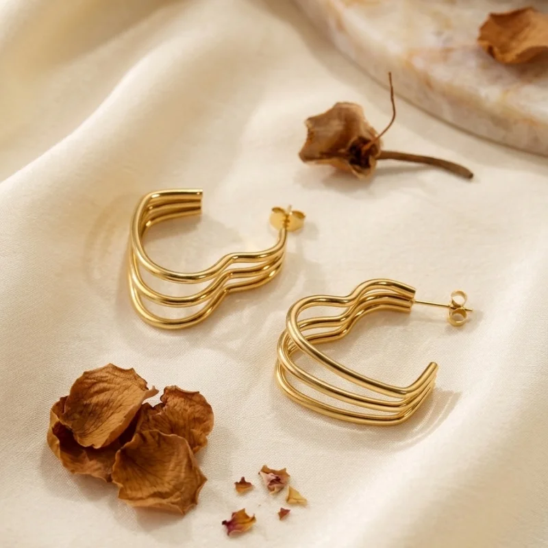 1 piece of stainless steel plated with 18k gold, featuring a heart-shaped curve and three-layer wave hollow C-shaped earrings. These earrings are designed for women in a light luxury, simple, trendy, and cool style, suitable for pairing with business suits and casual outfits. They have a unique design and are versatile, suitable for various occasions such as work, dates, parties, and travel