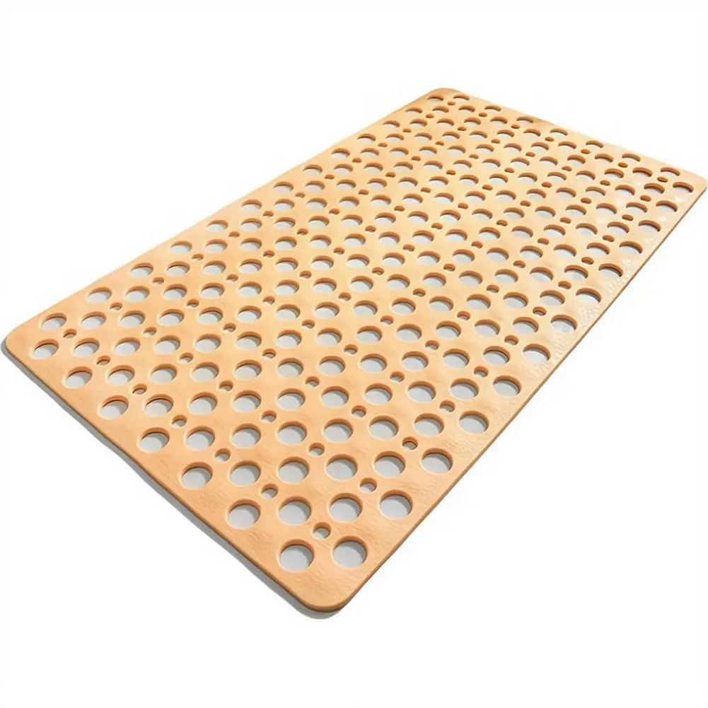 Grey round bathroom mat with suction cups and drainage holes on a wet shower floor.