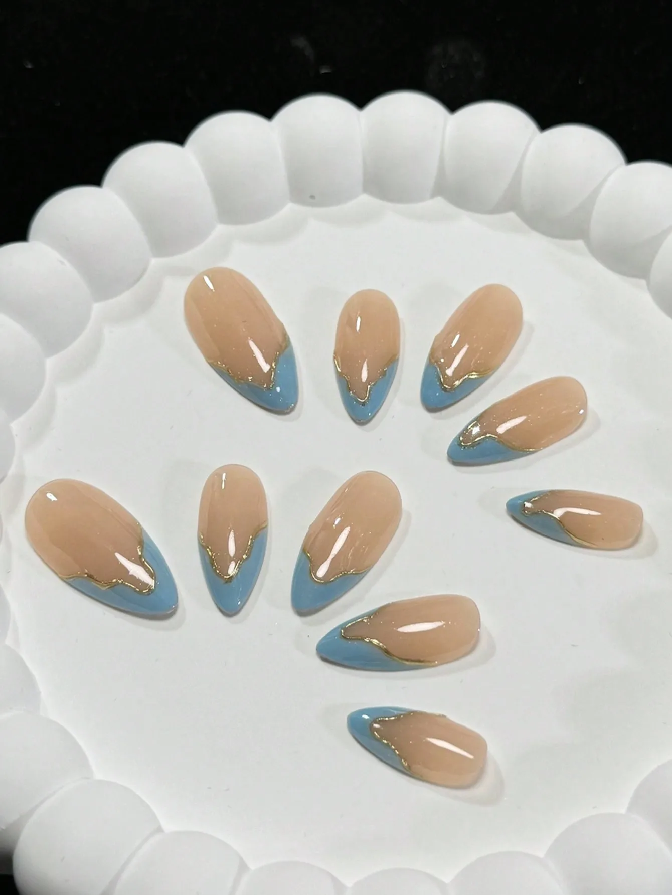 Dieci pezzi di unghie francesi irregolari nude e blu a forma di mandorla fatte a mano con contorno linea oro, fresche e semplici