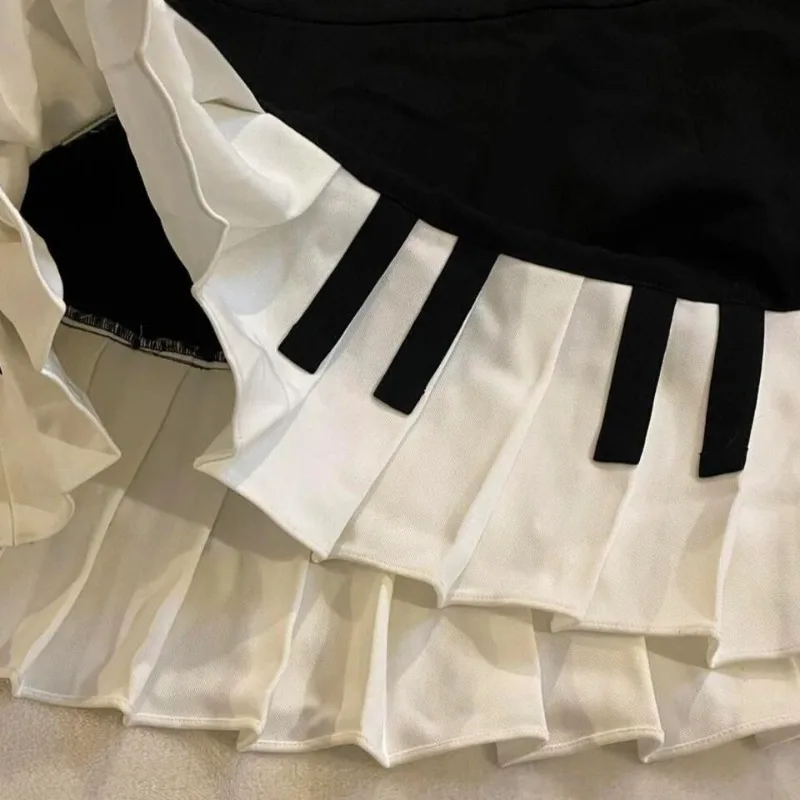 Mezza gonna a pieghe vintage a tema pianoforte in bianco e nero stile dolce e piccante primaverile con una figura lusinghiera e dimagrante