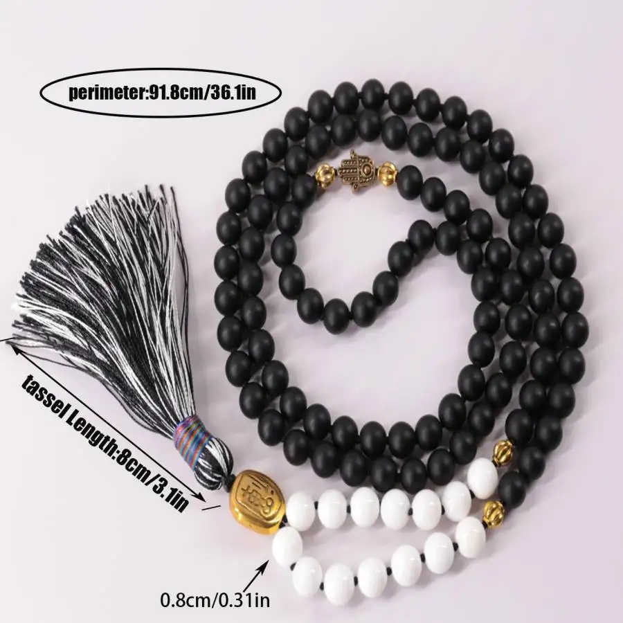 

Матовое ожерелье-мала из черного оникса и белых бусин (108 бусин) с символом Хамса и золотыми акцентами – защитное духовное украшение