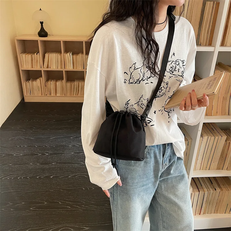 Women's Black Nylon Drawstring Bucket Bag with Adjustable Strap and Logo Detail Minimalist Crossbody Sling Purse for Daily view 3