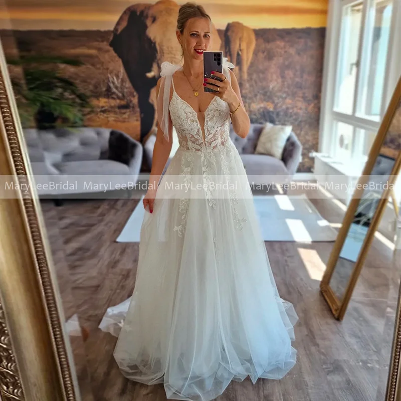 

Свадебное платье А-силуэта из тюля с прозрачным лифом, V-образным вырезом, на тонких бретелях, с кружевными аппликациями, в стиле бохо, для пляжной церемонии, на заказ.