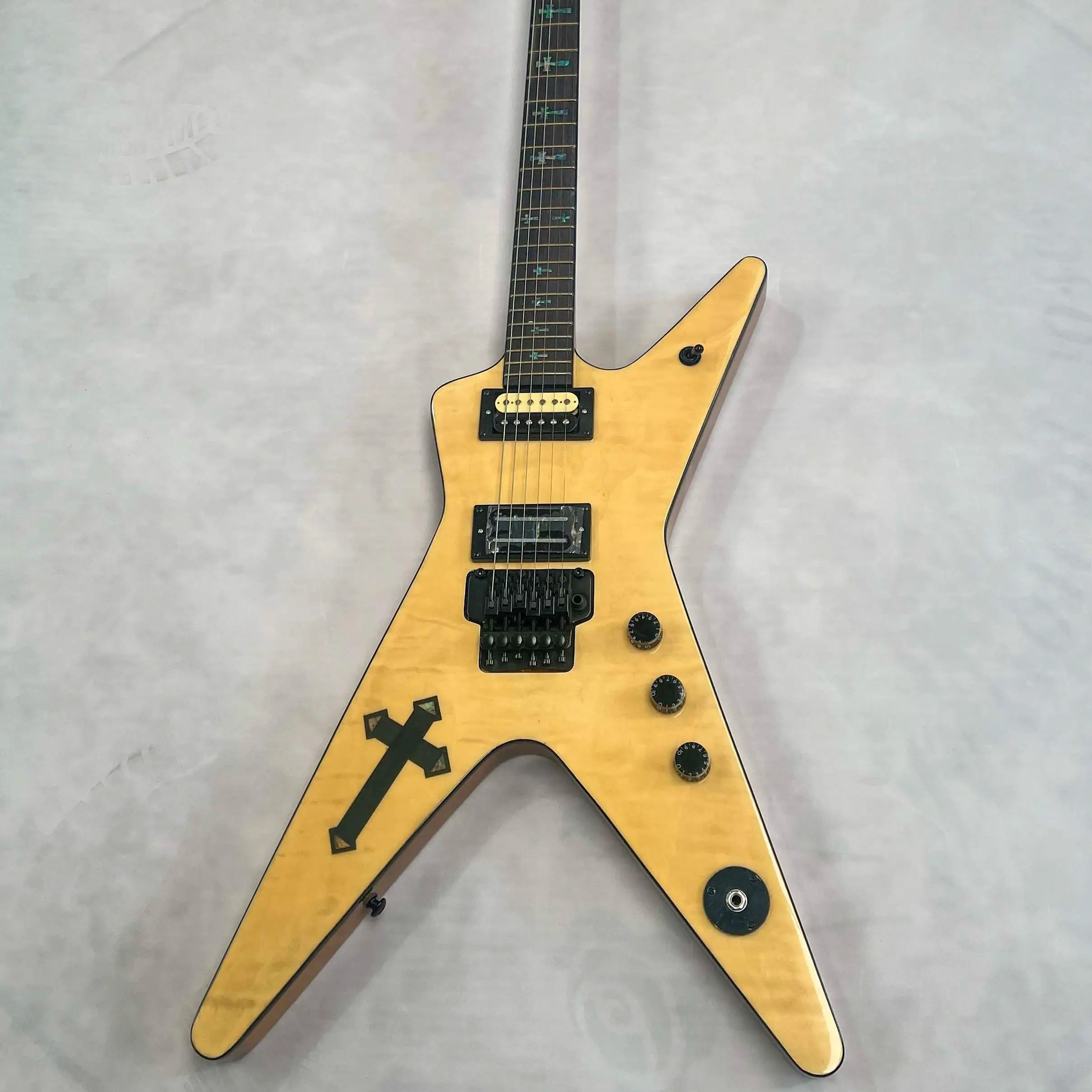 

Электрогитара с шестью струнами, формой вилки, звукоснимателями HH, тремоло-системой, цветом натурального дерева, корпусом с узором «крест».