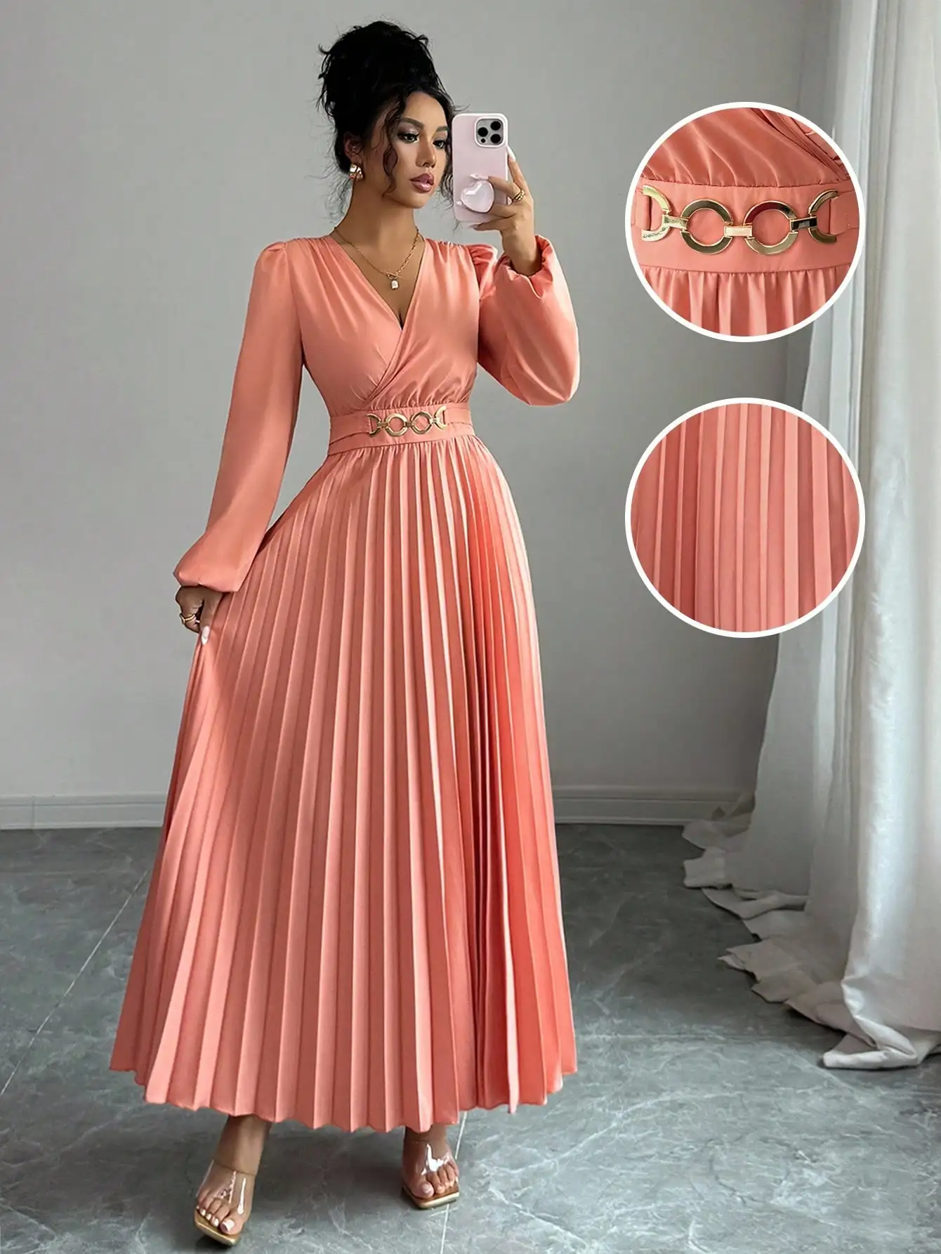 

Элегантное коралловое плиссированное макси-платье с V-образным вырезом, длинными рукавами и золотым поясом-цепочкой