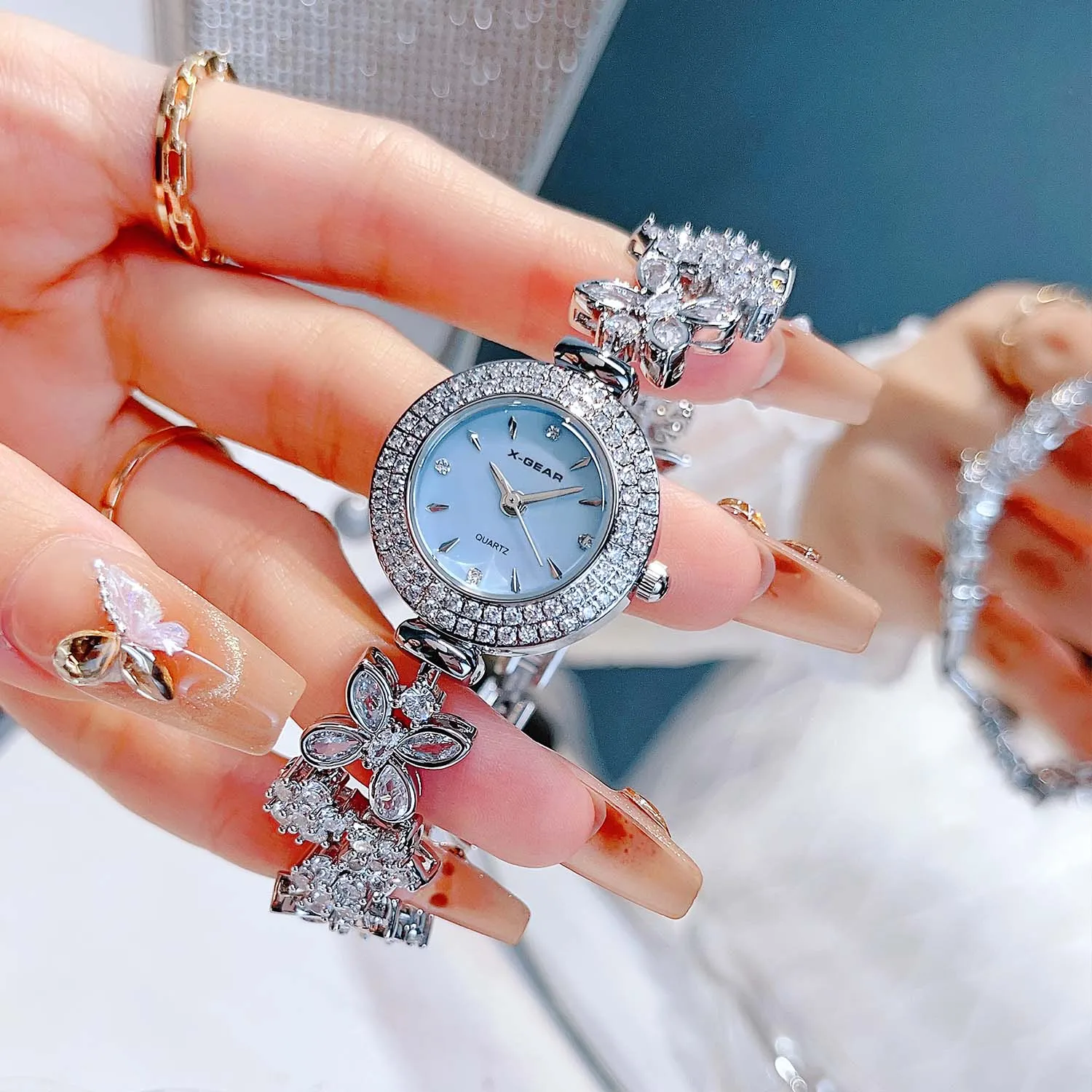 ساعة كوارتز X-GEAR باللون الذهبي - ساعة يد نسائية فاخرة من حجر الراين مع قرص أم اللؤلؤ وحزام سوار مجوهرات عصرية