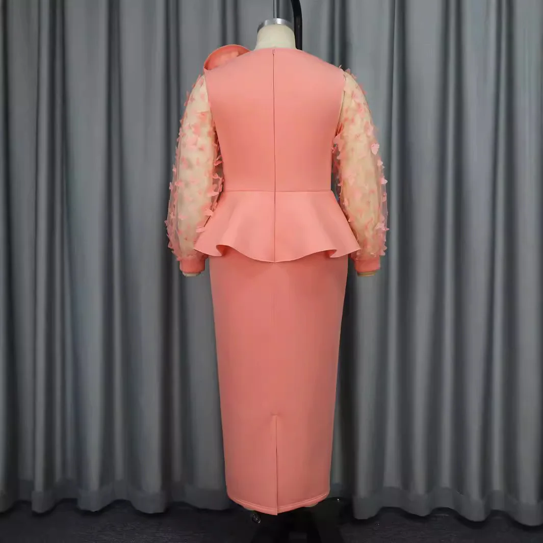 Elegancka sukienka wieczorowa plus size z falbanami w talii, kwiatami na ramionach i długimi, zwiewnymi rękawami z motywem motyla.