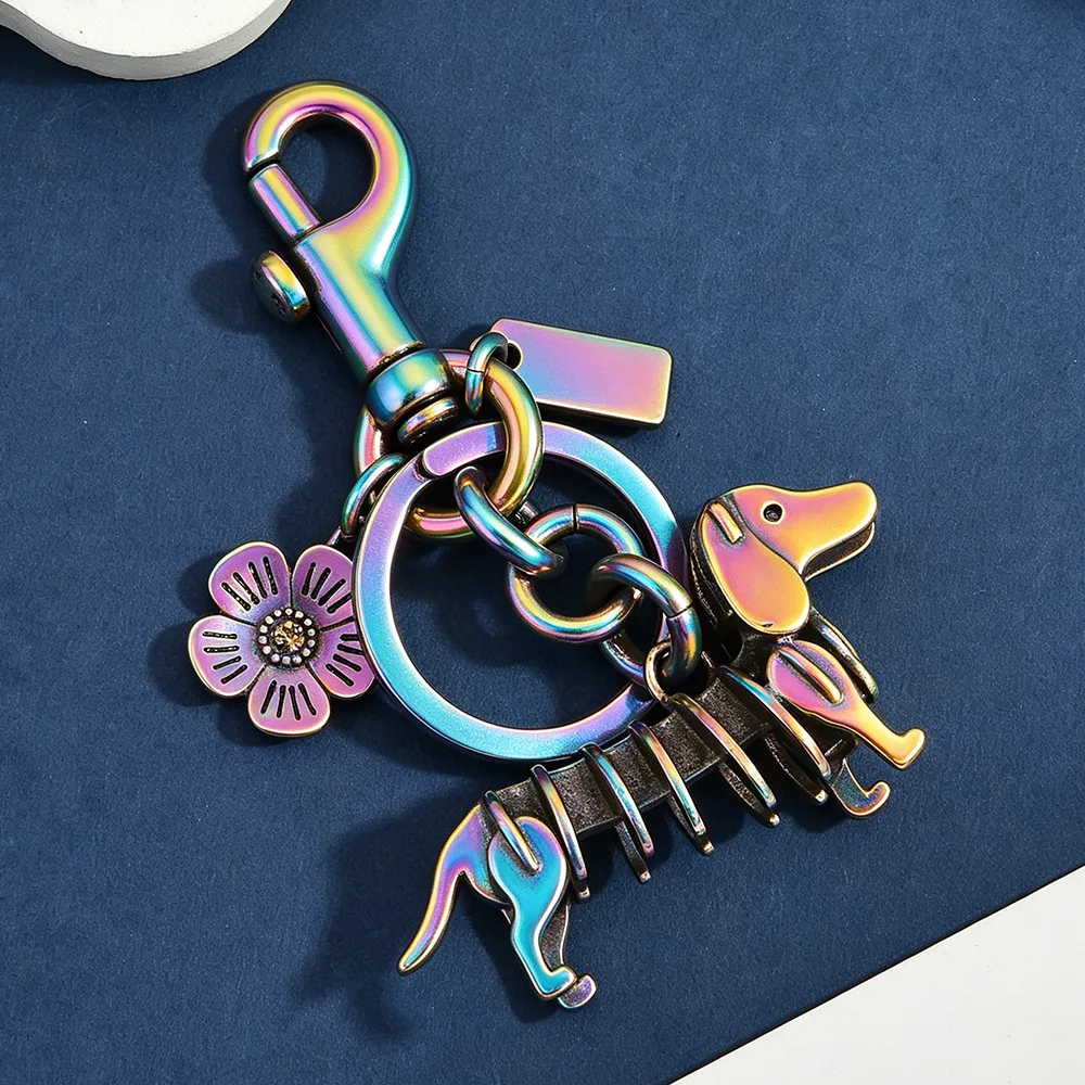 Retro metal dachshund keychains with flexible moving link bodies in rainbow, antique bronze, and silver finishes.