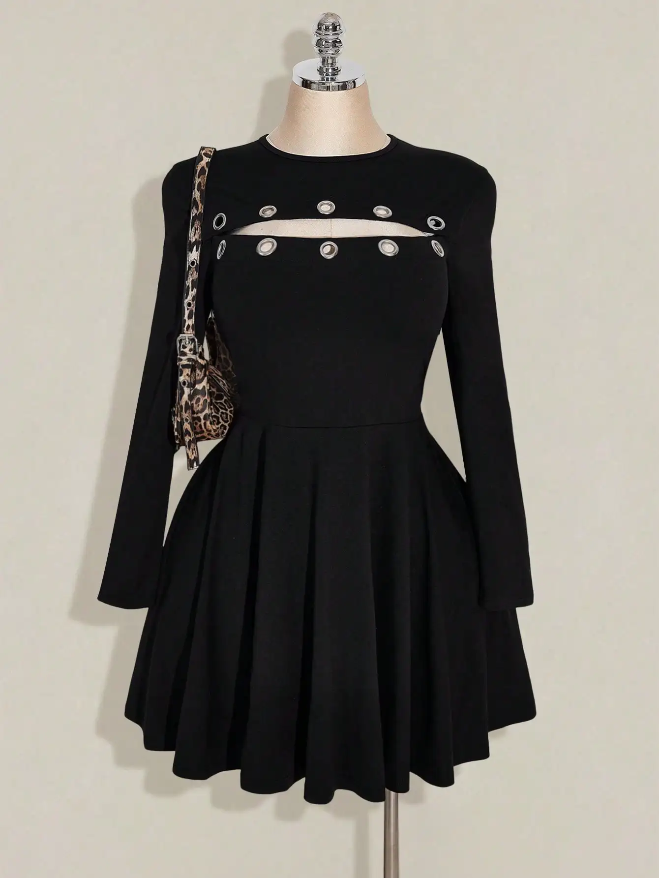 

Черное мини-платье с длинными рукавами, вырезами и металлическими люверсами, приталенное, с расклешенной юбкой