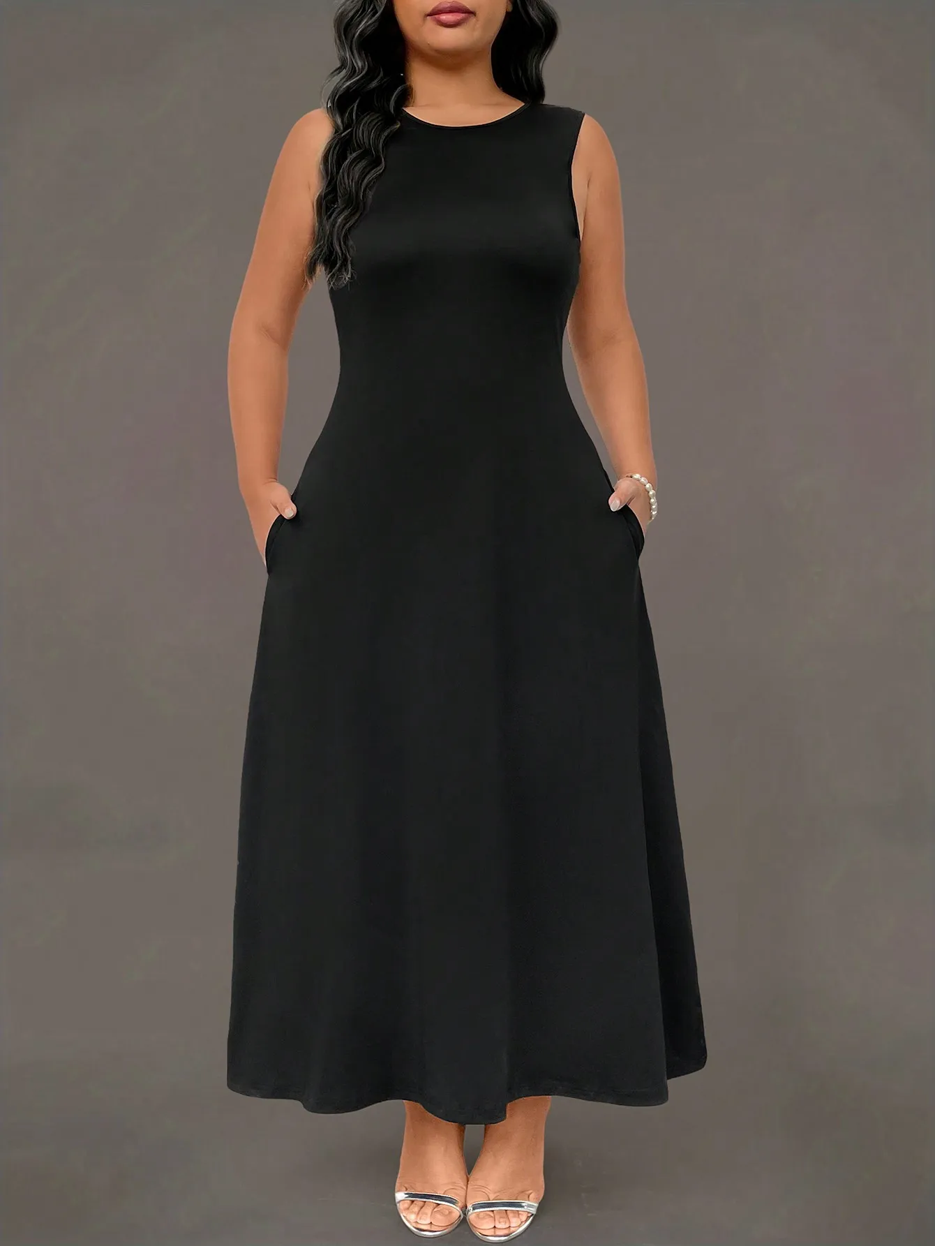 

Черное платье макси без рукавов с круглым вырезом и боковыми карманами, свободного кроя