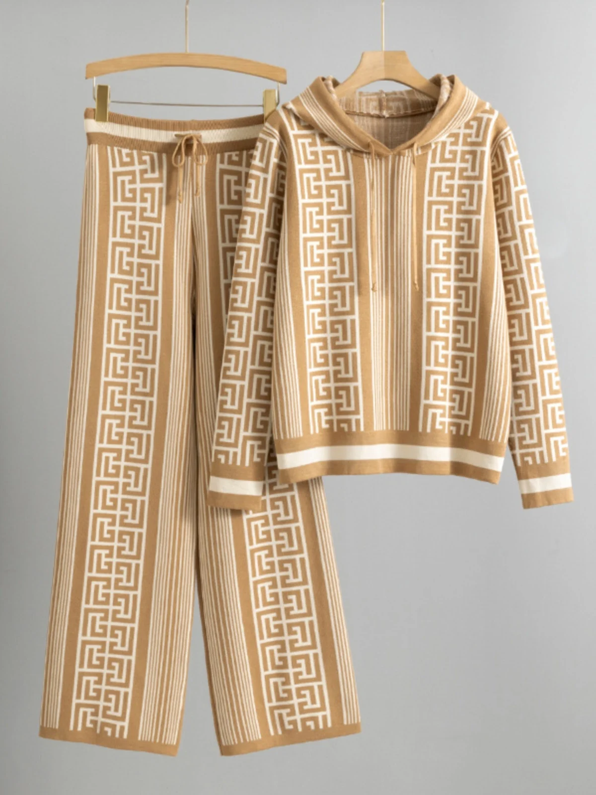 

Женский комплект: вязаный свитер с капюшоном и широкие брюки. Модный комплект с длинными рукавами и длинными брюками для осеннего сезона из полиэстера.