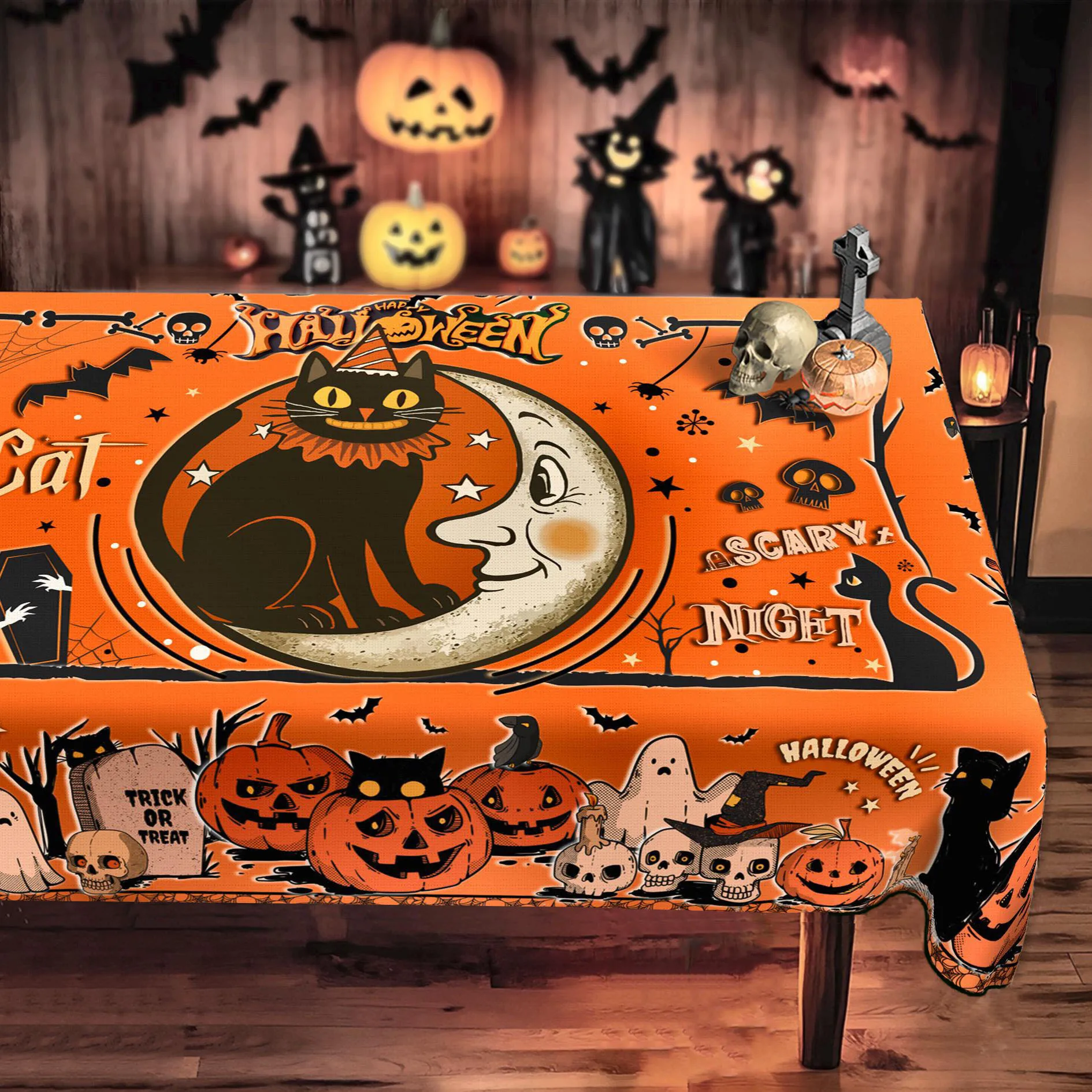 Happy Halloween tablecloth, featuring designs of black cats, full moons, pumpkins, ghosts, skulls and crows.PMJ
