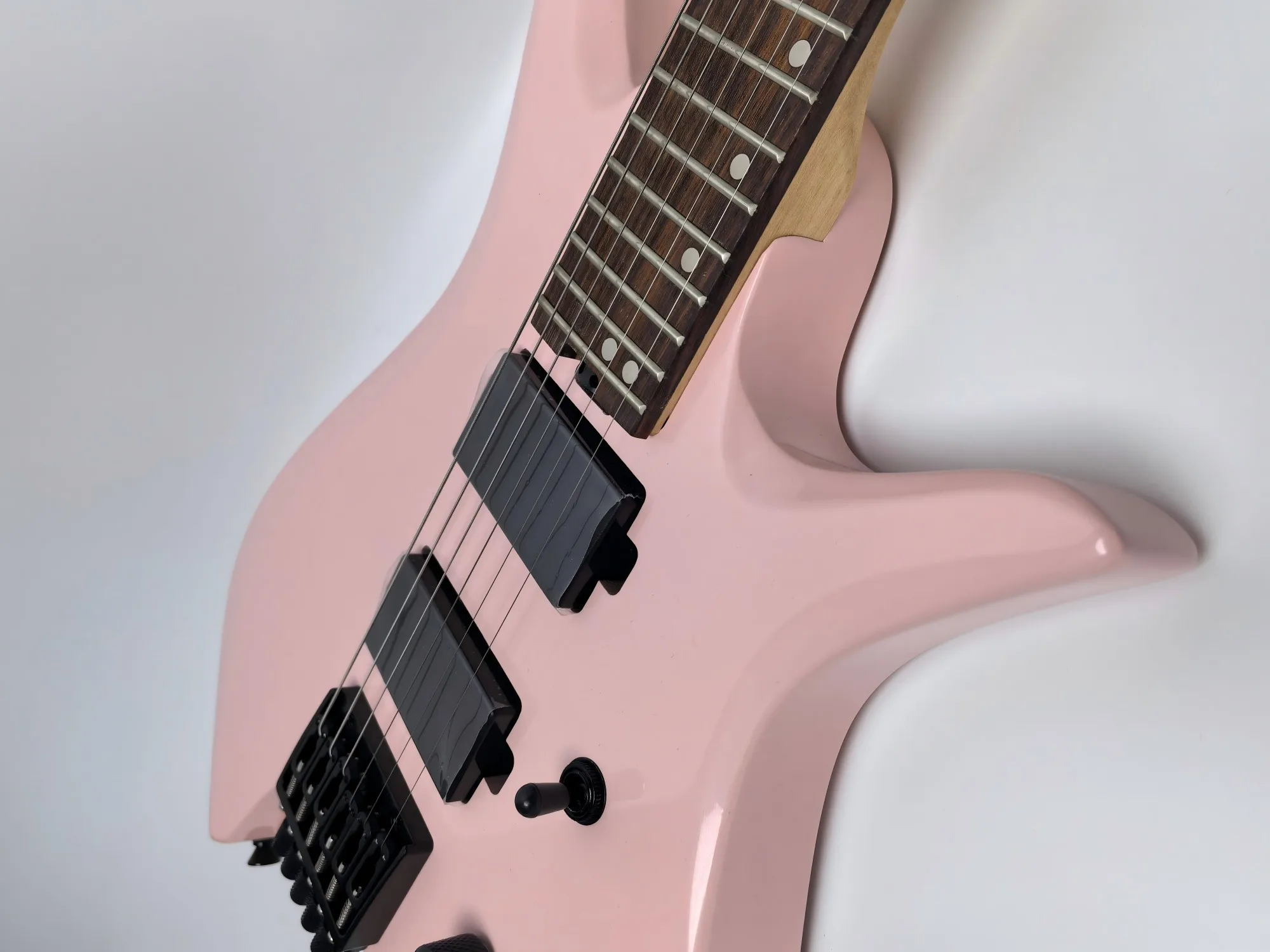 In stock. Can be shipped when placed. High quality pink headless 6 string electric guitar. Factory direct. Can be customized.