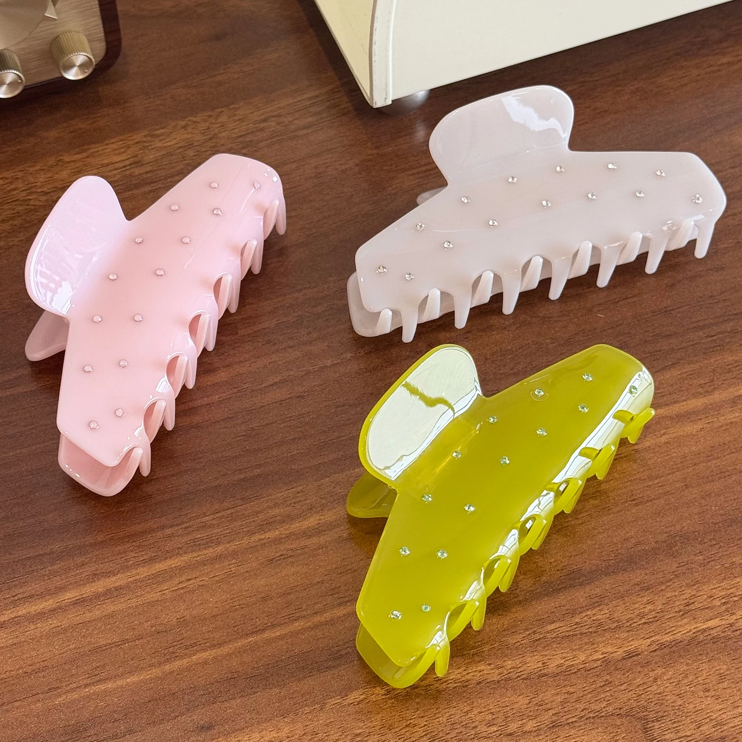 Um versátil grande grampo de cabelo de acetato com agarrador incrustado de diamantes e clipe de tubarão