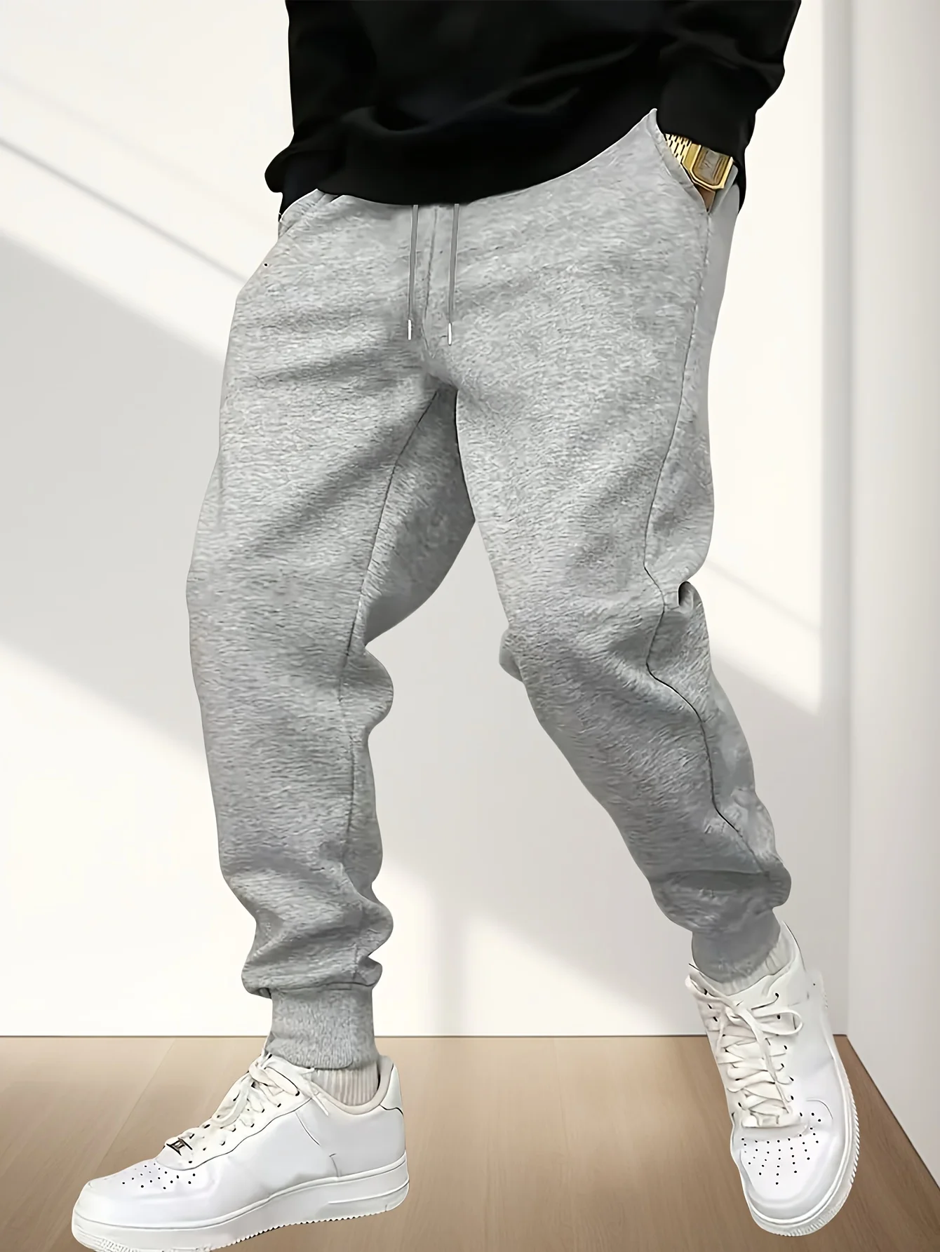 

Men's grey loose-fitting casual sweatpants with rolled-up ankle cuffs and drawstring waist, suitable for all seasons.