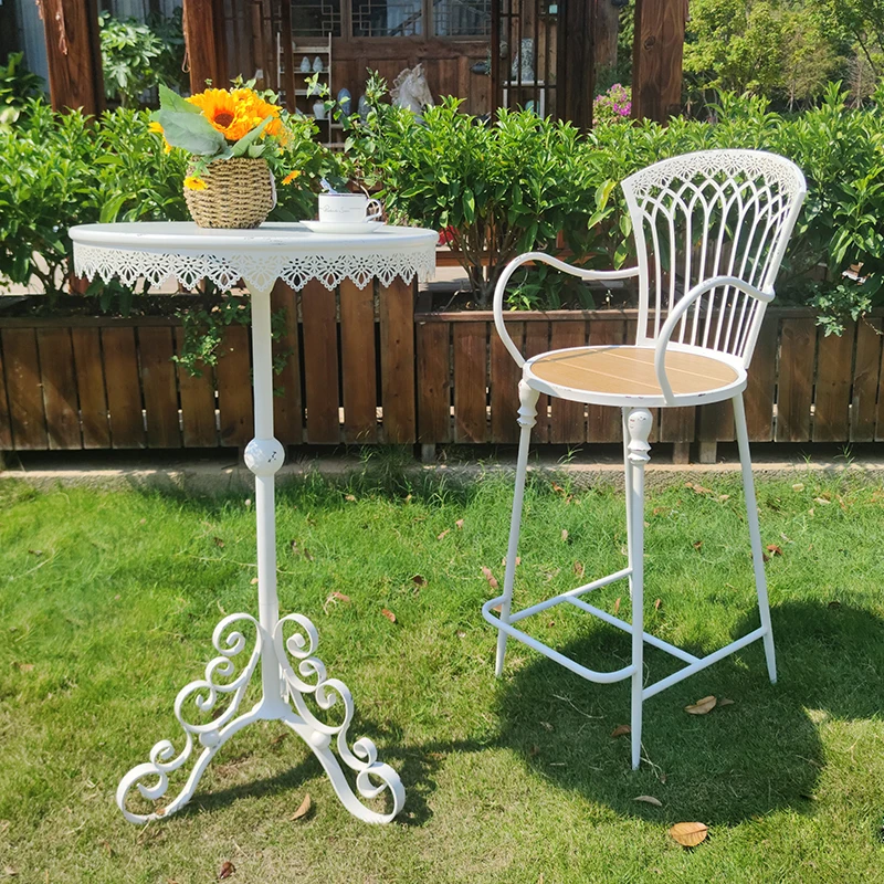 

Железные столы и стулья на высоких ножках, подходящие для садовых встреч.