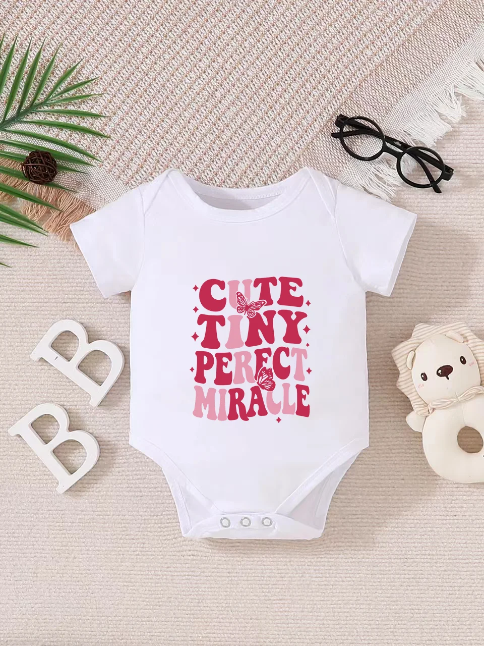 Playful letter-printed baby short-sleeve triangle bodysuit. Button closure for easy dressing, machine washable